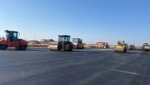 近日，在西部市政建設(shè)集團蘭州新區(qū)城市礦產(chǎn)與表面處理產(chǎn)業(yè)園區(qū)（二期）周邊基礎(chǔ)設(shè)施項目—園區(qū)西路南延段（緯五十路至緯二十八路）項目現(xiàn)場，隨著一輛輛運料車平穩(wěn)駛?cè)?，攤鋪機將滾燙的瀝青混合料均勻鋪開，標志著項